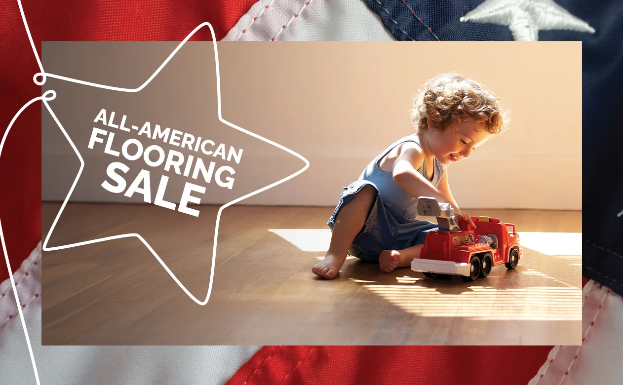 toddler playing with a fire truck on hard surface flooring